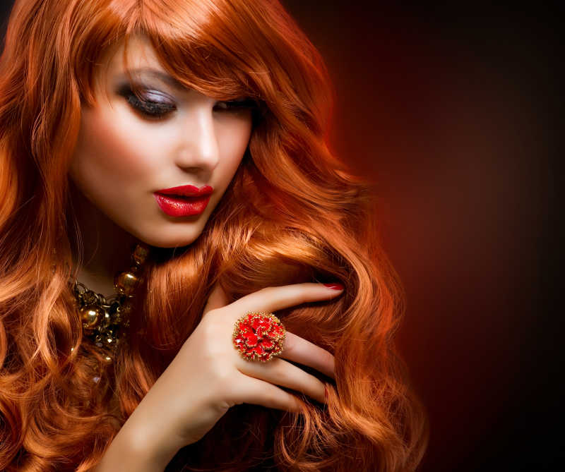 波浪状的红色头发的时尚女孩肖像