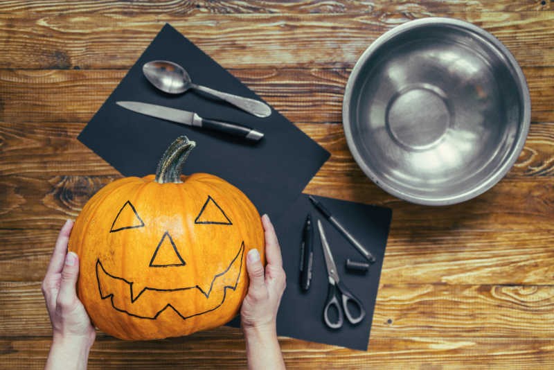 木桌上的各种工具和画好表情的南瓜