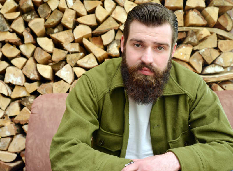 木材背景上梳着大背头的男人