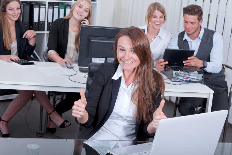 团队成员默契的合作竖起大拇指