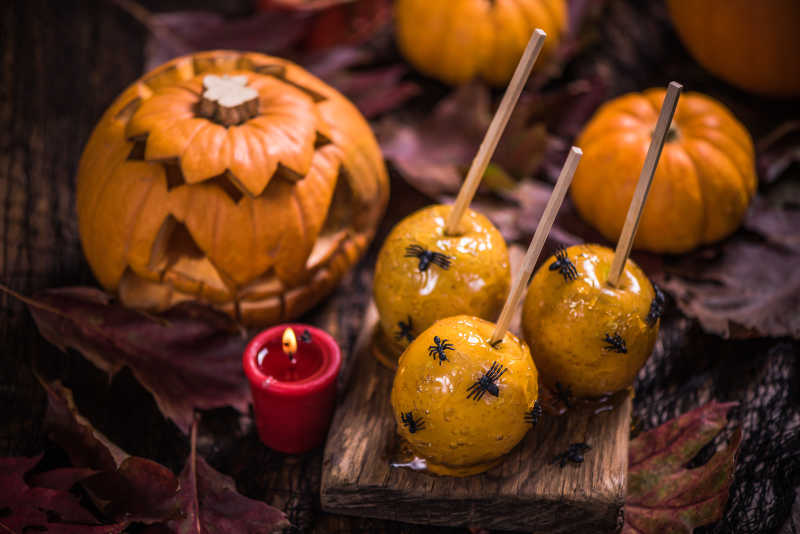 桌子上的万圣节南瓜灯和苹果糖果