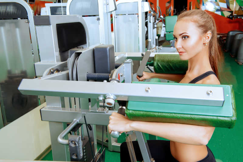 漂亮苗条的美女正在健身房训练