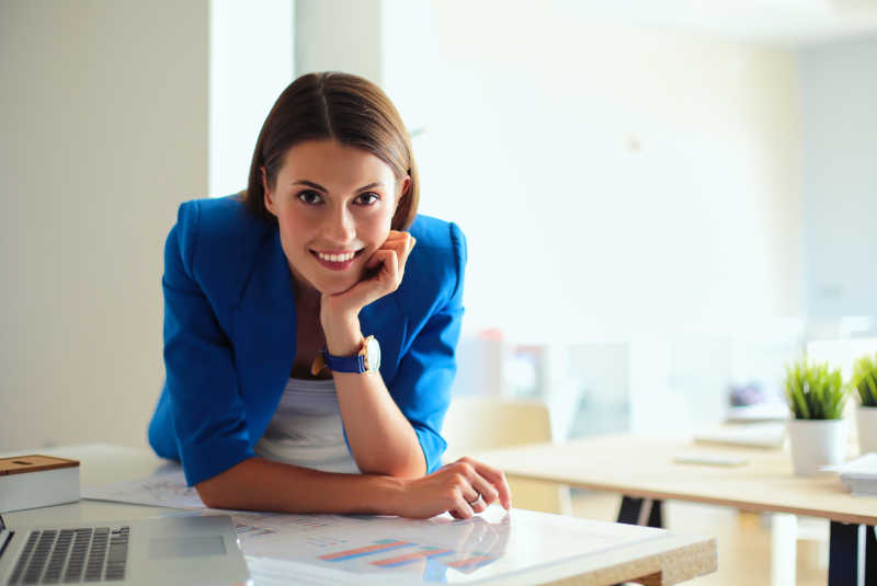 一个美丽的商人站在她工作场所附近