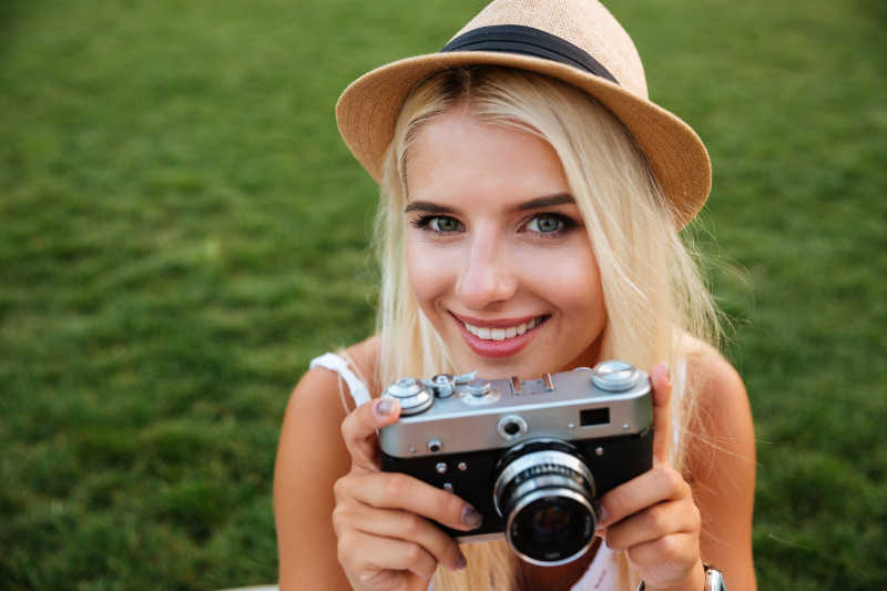 一位拿着照相机的年轻金发女郎