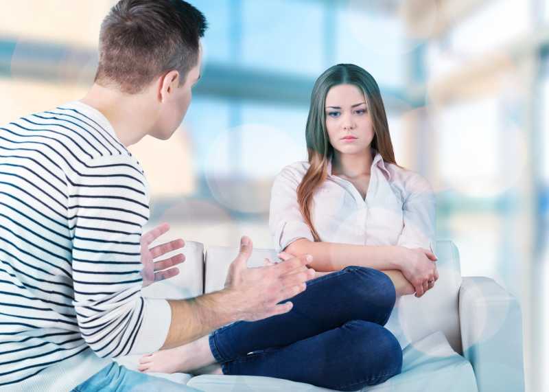 男人在和坐在沙发上的妻子说话