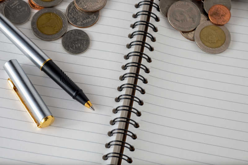 记事本上的硬币和笔