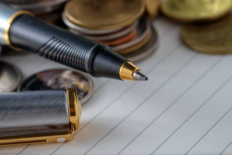 笔记本上的硬币和笔