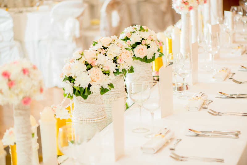 结婚婚礼餐桌上的玫瑰花和白色餐具装饰