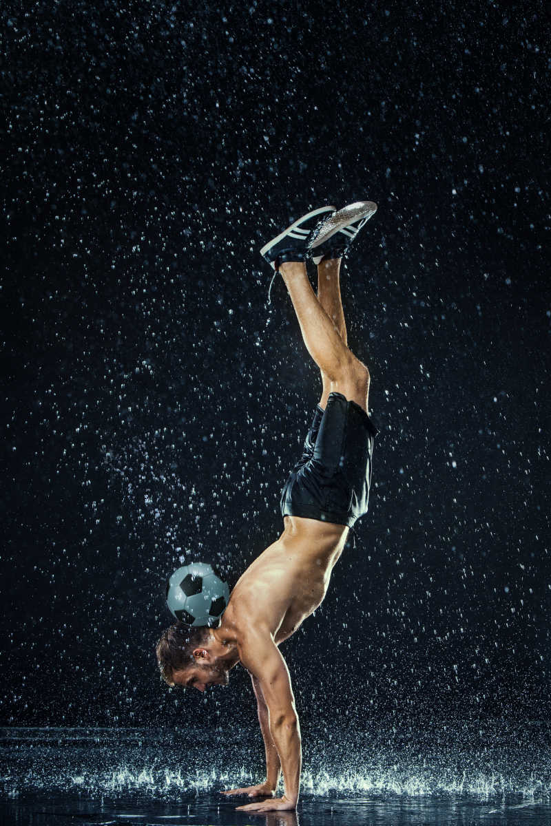 水滴在黑色背景上的足球运动员周围