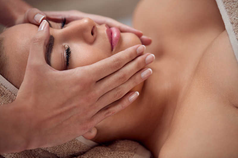 正在躺着享受皮肤护理按摩的美女