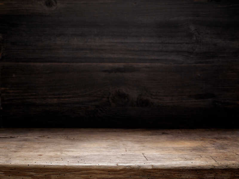 黑色背景下的原木色木纹理桌