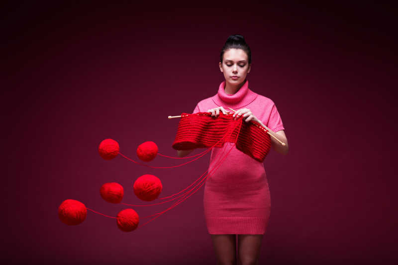 穿着粉色衣服的美女在织毛衣