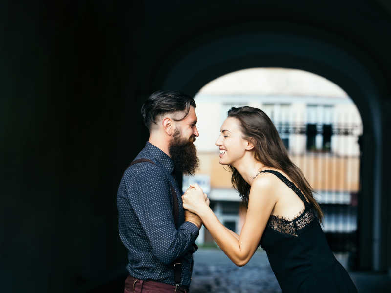 牵着手在对视的年轻时尚夫妇