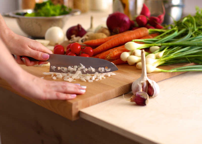 在木板上切菜的女人