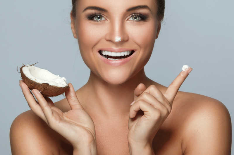 美丽的年轻女子拿着椰子