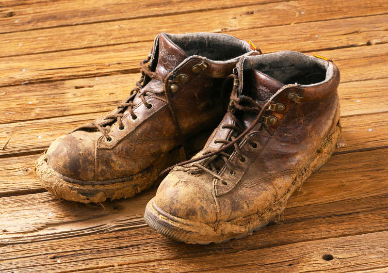 木地板上的沾满泥土的靴子