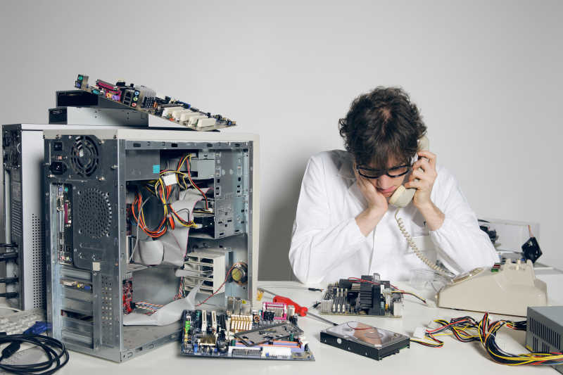 维修计算机的技术人员正在打电话