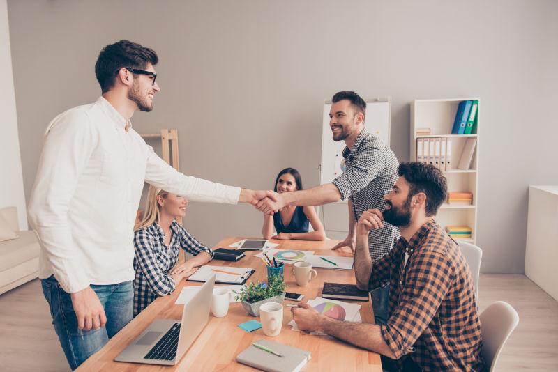 在一次商务会议上年轻工人互相握手