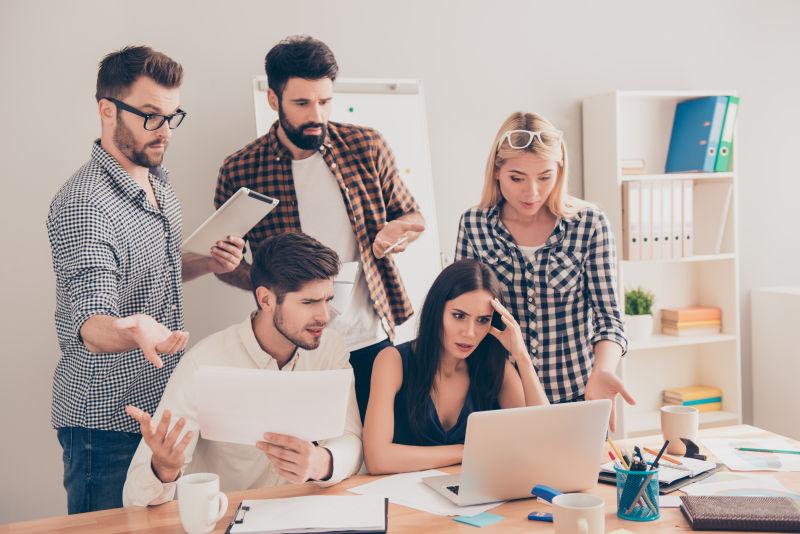 忧心忡忡的年轻同事在看笔记本电脑的会议上