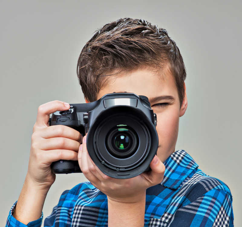 男孩用数码单反相机拍照