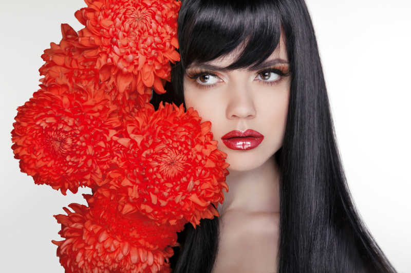 红唇黑发的美女和红色花朵