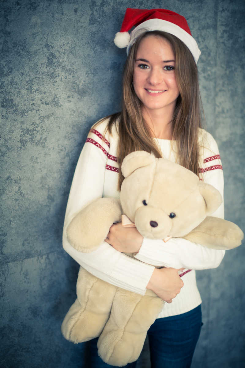 抱着泰迪熊的可爱圣诞女孩