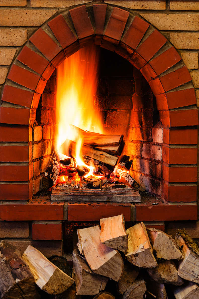 乡村别墅室内砖壁炉里燃烧的木材