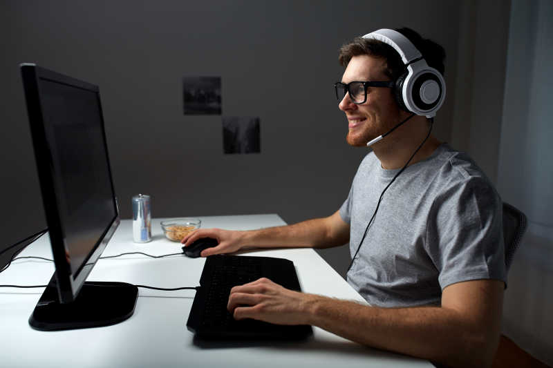 戴着耳机开心玩电脑的男人