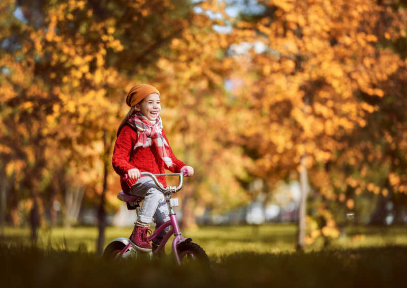 可爱的孩子在公园里骑着脚踏车