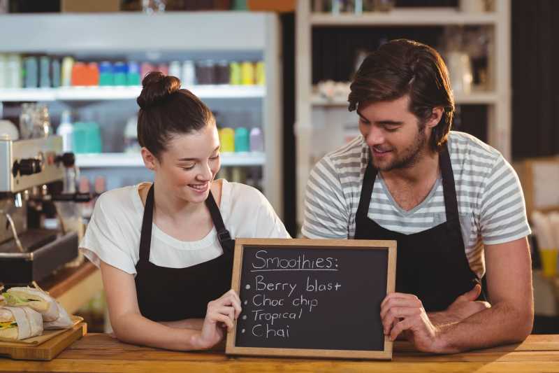 咖啡店店员手拿写着字的小黑板