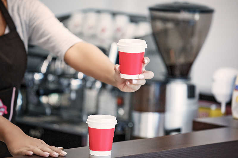 手拿一杯咖啡的女店员