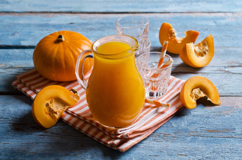 橙色南瓜和一杯南瓜汁
