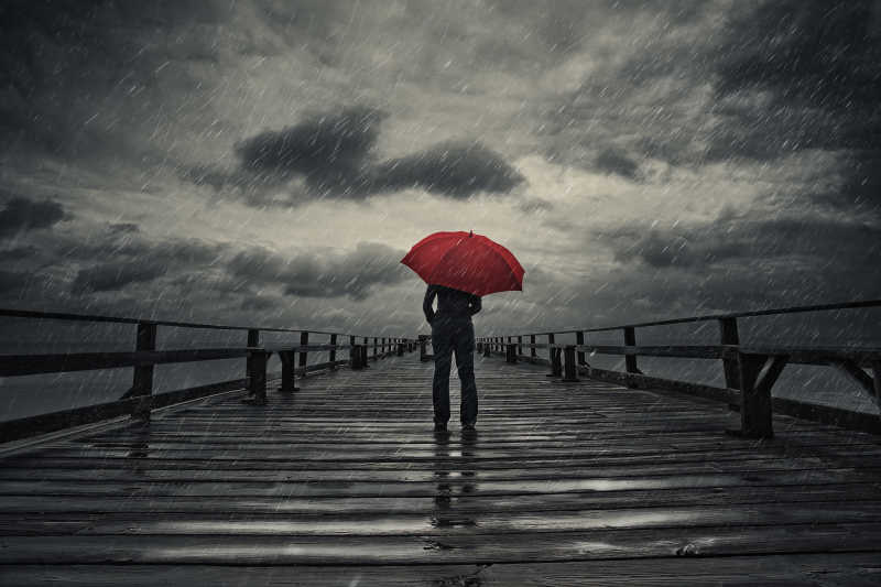 昏暗的天空下一个撑着伞的人