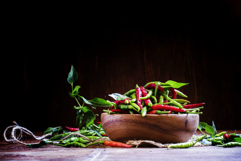 木制碗中的红色和绿色小辣椒