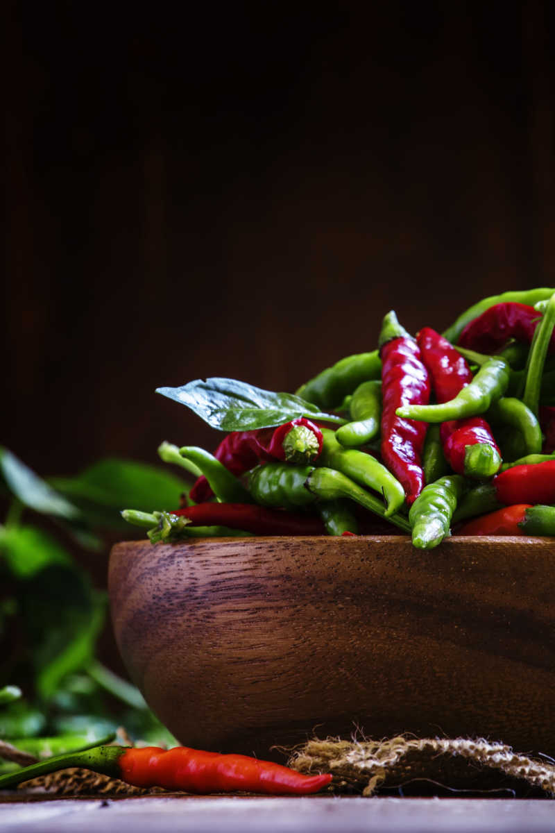 木制碗里的红色和绿色的小辣椒