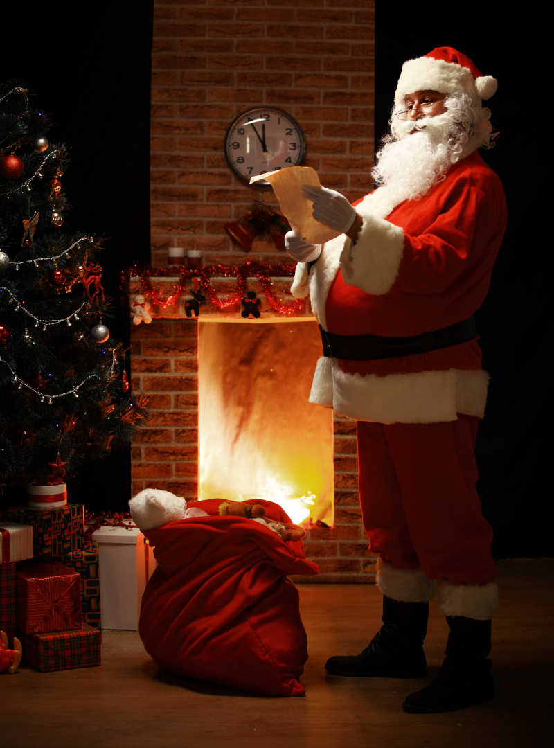 站在房中读圣诞信或愿望清单的圣诞老人