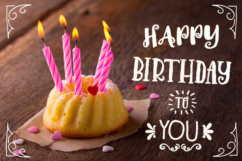 棕色木桌上的生日贺卡和小蛋糕