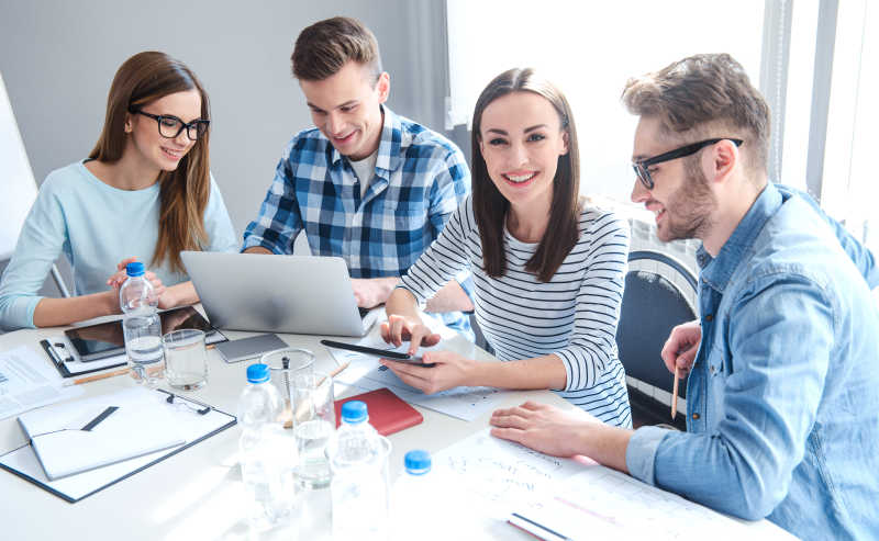 坐在办公桌上讨论工作的四个白领