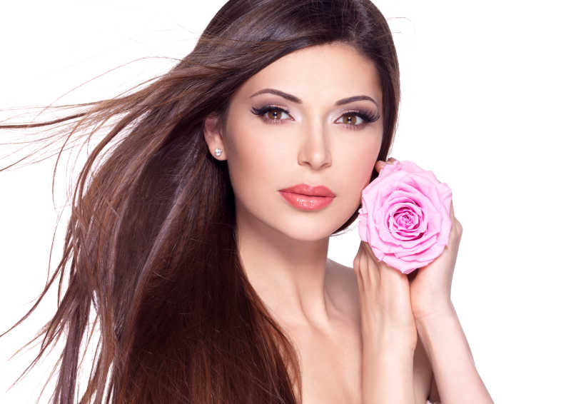 白色背景下的长发美女拿着粉红色的玫瑰的肖像