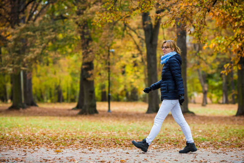 秋季公园里正在散步的女人