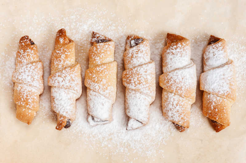 浅黄色背景下烘焙纸上新鲜烘焙的饼干