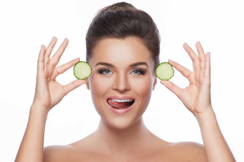 拿着黄瓜皮的年轻美女