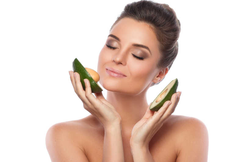 拿着鳄梨果实的年轻女人