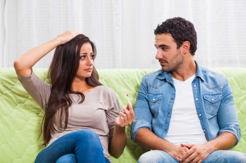 沙发上相互对视的年轻夫妻