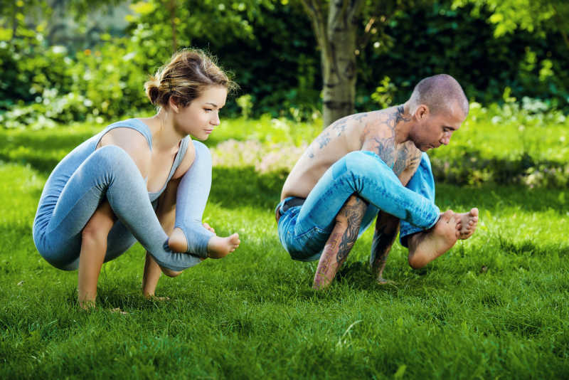 绿色的公园里锻炼瑜伽的情侣