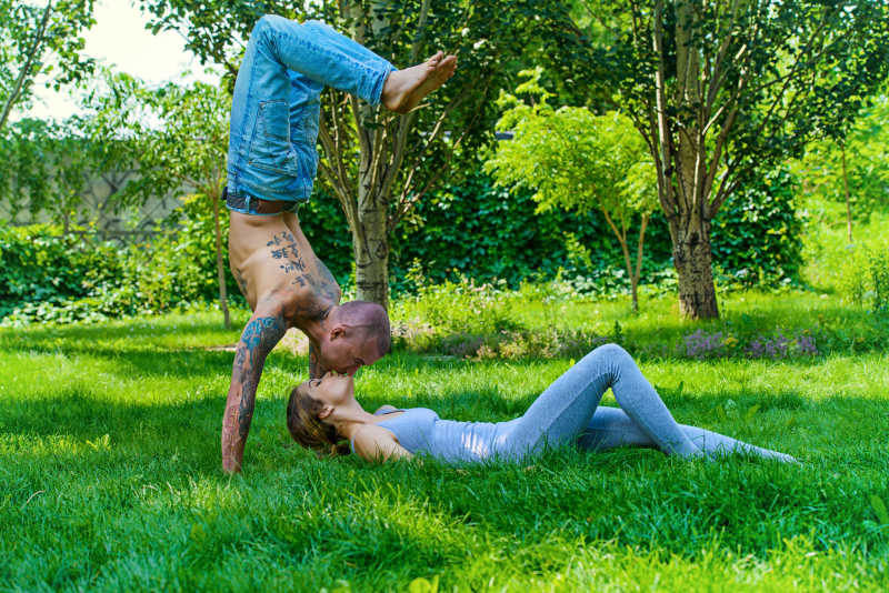户外草地上练习瑜伽的情侣