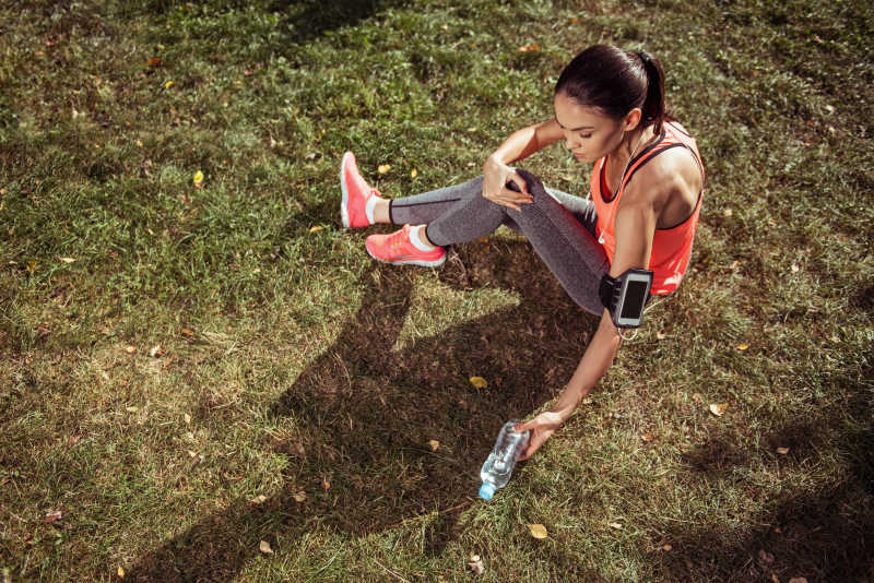 在户外晨练后休息的小女孩