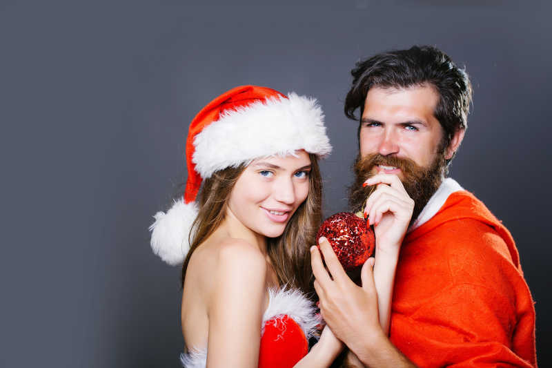 络腮胡穿着圣诞老人衣服和一个性感的圣诞美女