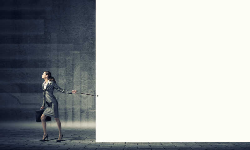 灰色背景下拉着白纸板走路的女商人