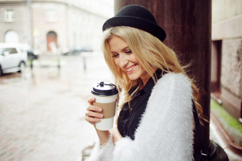 街头上美女拿着咖啡笑着